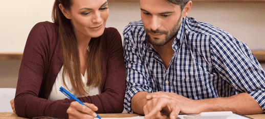 a couple sitting and discussing something. there is a pen in the girl's hand and she is making the person understand something