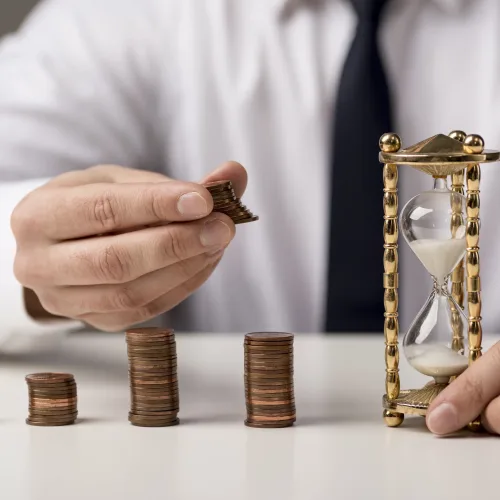 front-view-businessman-with-coins-hourglass-min front-view-businessman-with-coins-hourglass-min